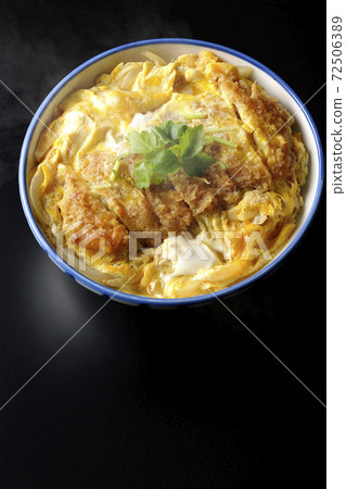 A single shot of a hot katsudon in a bowl with a black background (overhead view) 72506389