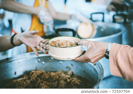Volunteers give food to the poor Volunteers give food to the poor 72507704