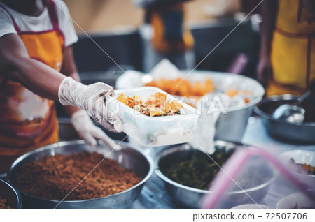 Volunteers give food to the poor 72507706