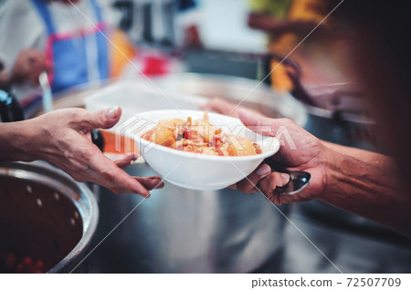 Volunteers give food to the poor 72507709