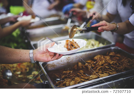 Volunteers give food to the poor 72507710