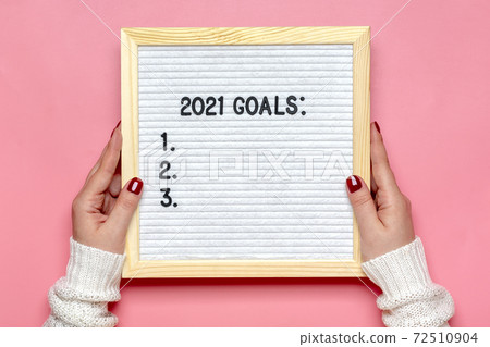 female hands holds felt board with text - 2021 goals on pink background Planning, self motivation, achievement, success, wish list, checklist concept Top view Flat lay Motivational quote, message female hands holds felt board with text - 2021 goals on pink background Planning, self motivation, achievement, success, wish list, checklist concept Top view Flat lay Motivational quote, message 72510904