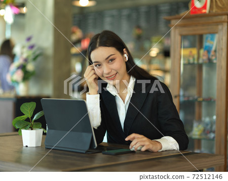 Businesswoman smiling to camera while take a break from work in cafe Businesswoman smiling to camera while take a break from work in cafe 72512146