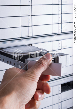 hand of a technician swapping hard drive with SAS interface insi 72512296