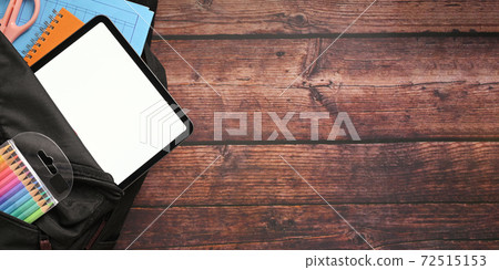 Black screen tablet in school backpack with education supplies. Black screen tablet in school backpack with education supplies. 72515153