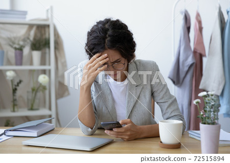 Concerned young woman florist tailor getting email with bad news Concerned young woman florist tailor getting email with bad news 72515894