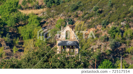 Vintage belfry long shot against the hillside 72517554