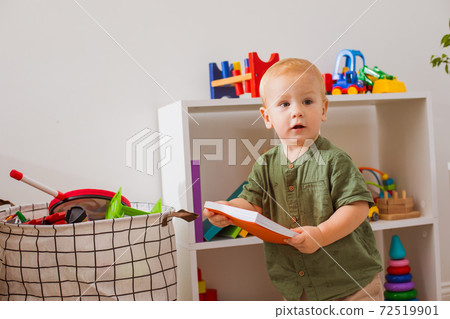 The baby boy learns to read in the kindergarten 72519901
