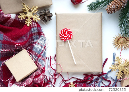 Present in brown craft paper, boxes, candy, plaid and Christmas decoration on table. Copy space. Eco friendly New Year 72520855