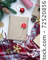 Present in brown craft paper, boxes, candy, plaid and Christmas decoration on table. Copy space. Eco friendly New Year 72520856