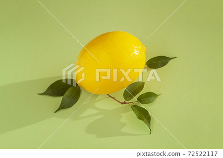 One yellow lemon on tender green background, top view. Juicy natural summer vitamin and diet concept 72522117