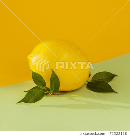Ripe lemon with a leaf on bicolor multicolored background. Juicy summer vitamin C, citrus minimal concept. Ripe lemon with a leaf on bicolor multicolored background. Juicy summer vitamin C, citrus minimal concept. 72522118