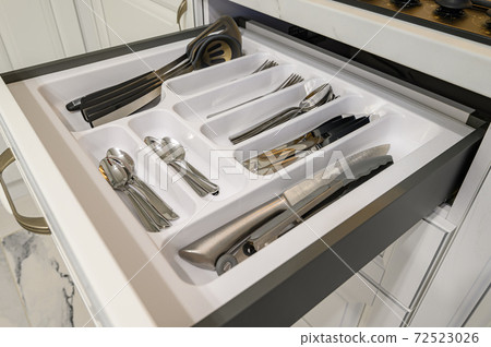 Open drawer with cutlery at modern white woden kitchen in classic style Open drawer with cutlery at modern white woden kitchen in classic style 72523026