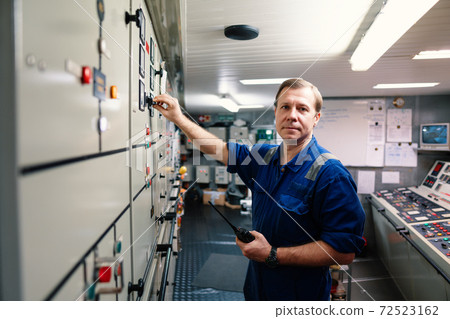 Marine engineer officer controlling vessel engines and propulsion in engine control room Marine engineer officer controlling vessel engines and propulsion in engine control room 72523162