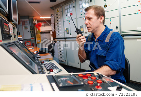 Marine engineer officer controlling vessel engines and propulsion in engine control room Marine engineer officer controlling vessel engines and propulsion in engine control room 72523195