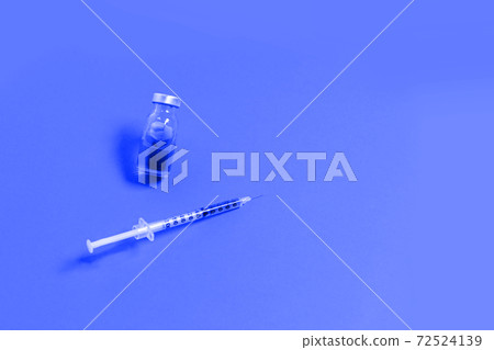 Syringe with blue medicine liquid on an isolated blue background. Vaccination, immunity, cosmetology concept Syringe with blue medicine liquid on an isolated blue background. Vaccination, immunity, cosmetology concept 72524139