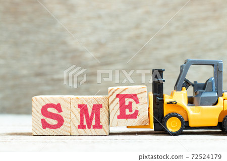 Toy forklift hold letter block e to complete word SME (abbreviation of Small and medium sized enterprises) on wood background Toy forklift hold letter block e to complete word SME (abbreviation of Small and medium sized enterprises) on wood background 72524179