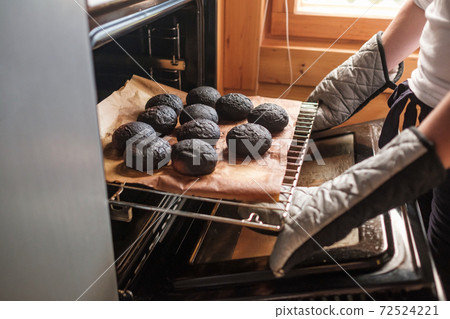 Failed cooking in kitchen. Woman holding a tray of spoiled muffins Failed cooking in kitchen. Woman holding a tray of spoiled muffins 72524221