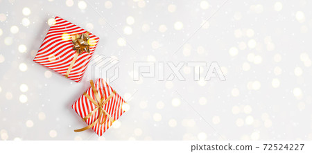 Trendy Happy New Year banner. Christmas design red gifts box, golden bow, glitter light on white background. Trendy Happy New Year banner. Christmas design red gifts box, golden bow, glitter light on white background. 72524227