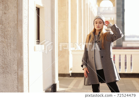 blond girl in knitted hat and coat with maple leaf close up portrait on city architecture background blond girl in knitted hat and coat with maple leaf close up portrait on city architecture background 72524479