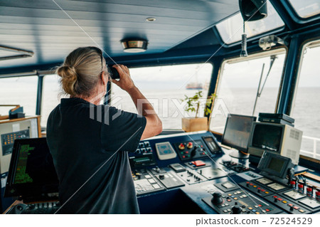 Captain of vessel or ship. He is looking through binoculars Captain of vessel or ship. He is looking through binoculars 72524529