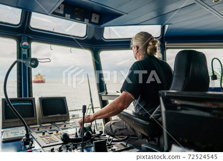Captain of deck Officer on bridge of vessel or ship during navigaton watch at sea Captain of deck Officer on bridge of vessel or ship during navigaton watch at sea 72524545