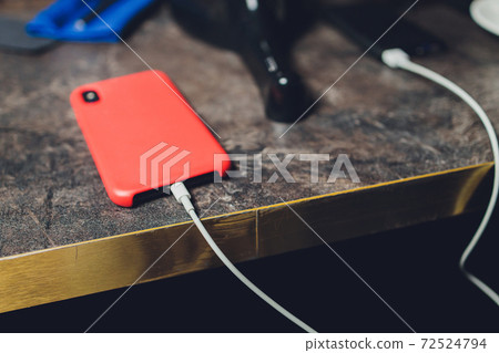 Charging Smartphone With Grey Portable External Battery powerbank on Wooden Table . 72524794