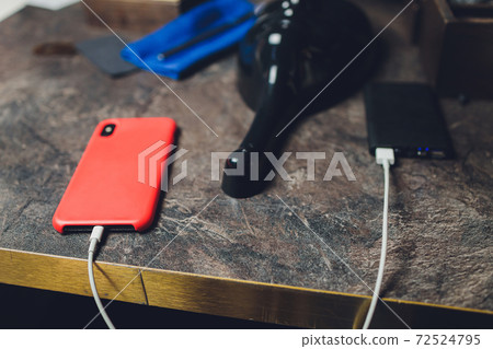 Charging Smartphone With Grey Portable External Battery powerbank on Wooden Table . 72524795