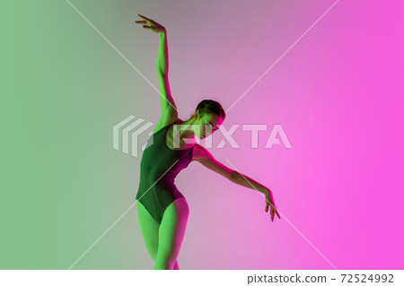 Young and graceful ballet dancer isolated on gradient pink-green studio background in neon light. Art in motion Young and graceful ballet dancer isolated on gradient pink-green studio background in neon light. Art in motion 72524992