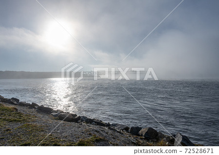 A bridge in fog. Blue ocean and mist in the background. Picture from the bridge connecting Sweden with Denmark A bridge in fog. Blue ocean and mist in the background. Picture from the bridge connecting Sweden with Denmark 72528671