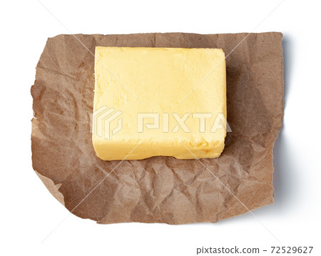 Fresh butter on craft paper isolated on white background Fresh butter on craft paper isolated on white background 72529627