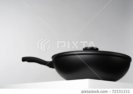 New black frying pan against grey background 72531151