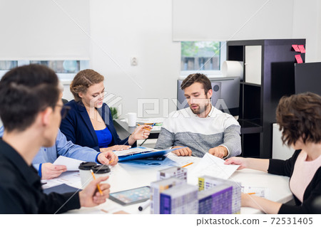 A group of architect bureau employees brainstorming together, wo 72531405