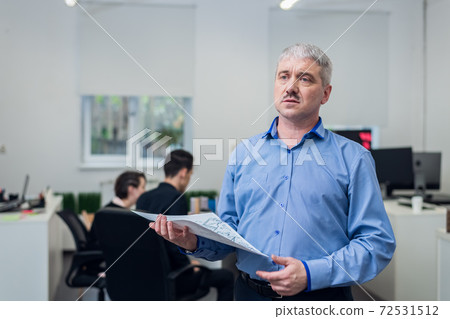 A portrait of the head of an architect bureau with his team in t A portrait of the head of an architect bureau with his team in t 72531512