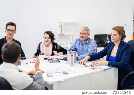 A group of architect bureau employees brainstorming together, wo A group of architect bureau employees brainstorming together, wo 72531546