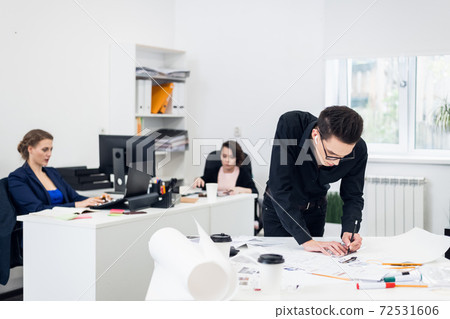 Young Male architect working on a project in a bright spacious o 72531606