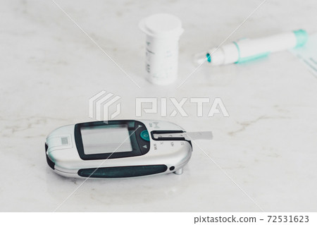 Blood glucose meter, glucometer and patient, the procedure takes place in the laboratory. Blood glucose meter, glucometer and patient, the procedure takes place in the laboratory. 72531623