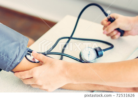Measurement of heart and blood pressure using a tonometer, patient and doctor. Measurement of heart and blood pressure using a tonometer, patient and doctor. 72531626