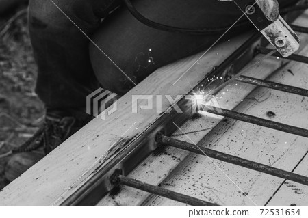 A man welds a metal frame to build an aviary, welding metal close up. 72531654