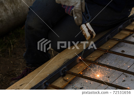A man welds a metal frame to build an aviary, welding metal close up. 72531656