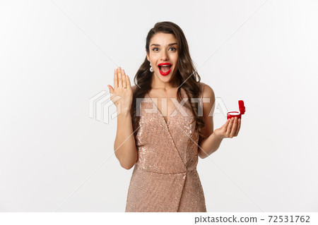 Image of excited woman showing her wedding ring on finger and looking happy, say yes to marriage proposal, being engaged Image of excited woman showing her wedding ring on finger and looking happy, say yes to marriage proposal, being engaged 72531762