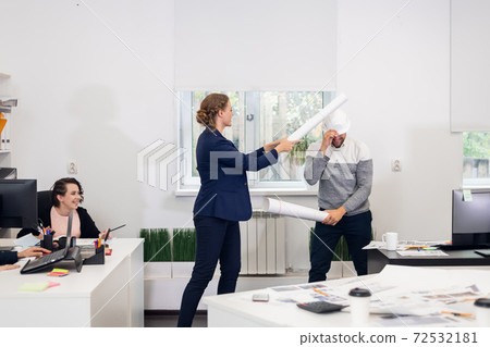 Office workers fooling in the studio, fighting with improvised s Office workers fooling in the studio, fighting with improvised s 72532181