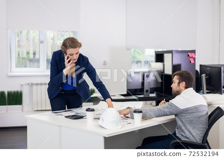 A woman talking on a phone and searching for some documents in t 72532194