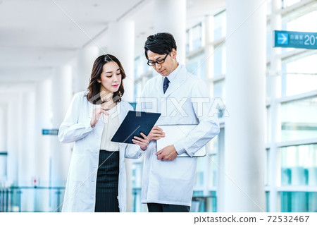Medical image of men and women in lab coats meeting at the hospital Medical image of men and women in lab coats meeting at the hospital 72532467