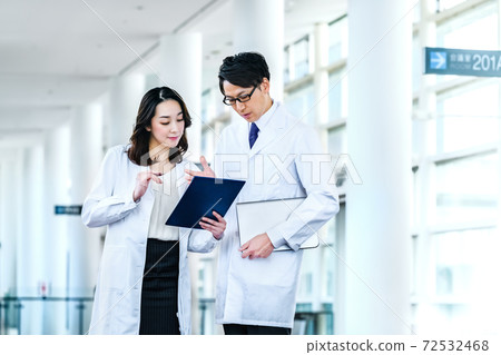 Medical image of men and women in lab coats meeting at the hospital Medical image of men and women in lab coats meeting at the hospital 72532468