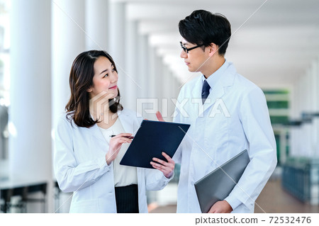 Medical image of men and women in lab coats meeting at the hospital Medical image of men and women in lab coats meeting at the hospital 72532476