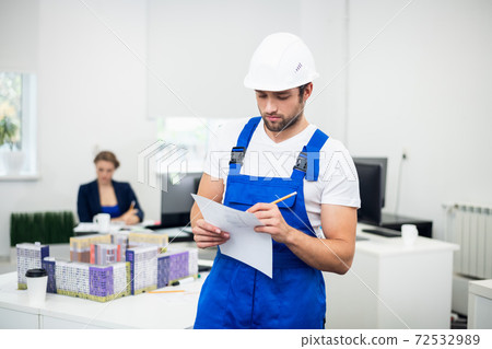 A portrait of a handsome construction engineer taking notes whil A portrait of a handsome construction engineer taking notes whil 72532989