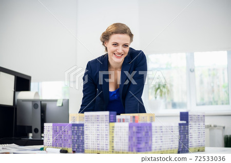 A beautiful young real estate sales manager in her office A beautiful young real estate sales manager in her office 72533036