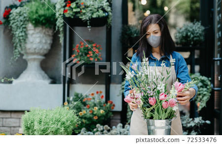 Florist arranging bouquet of beautiful colorful flowers in shop Florist arranging bouquet of beautiful colorful flowers in shop 72533476