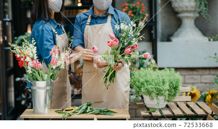 Male and female florists focused on composition in flower shop Male and female florists focused on composition in flower shop 72533668